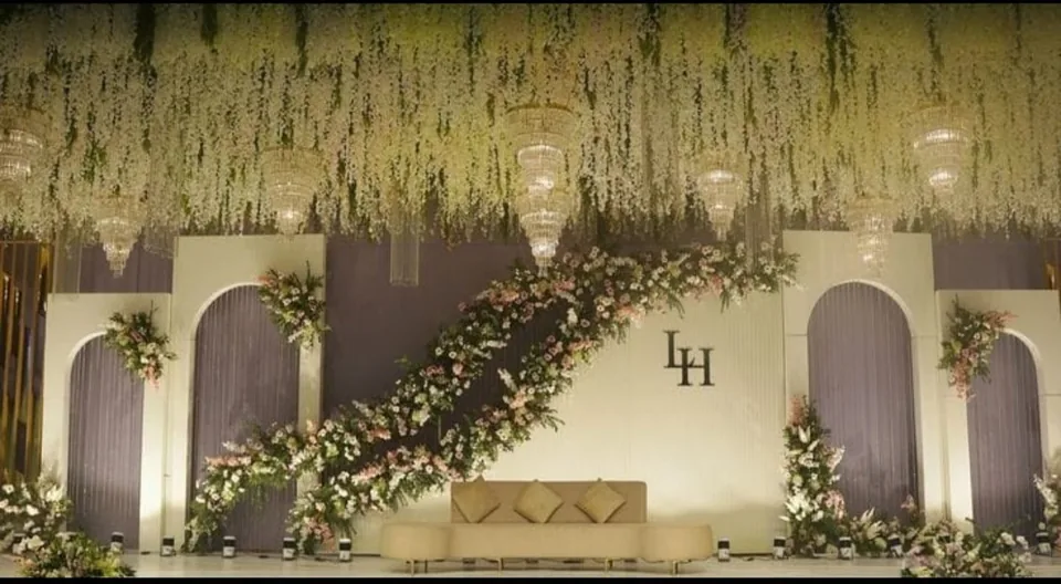 Reception stage with cascading white wisteria and lounge seating