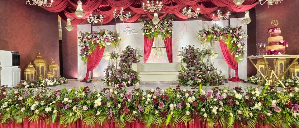 Traditional stage with red drape accents, florals and tiered cake table