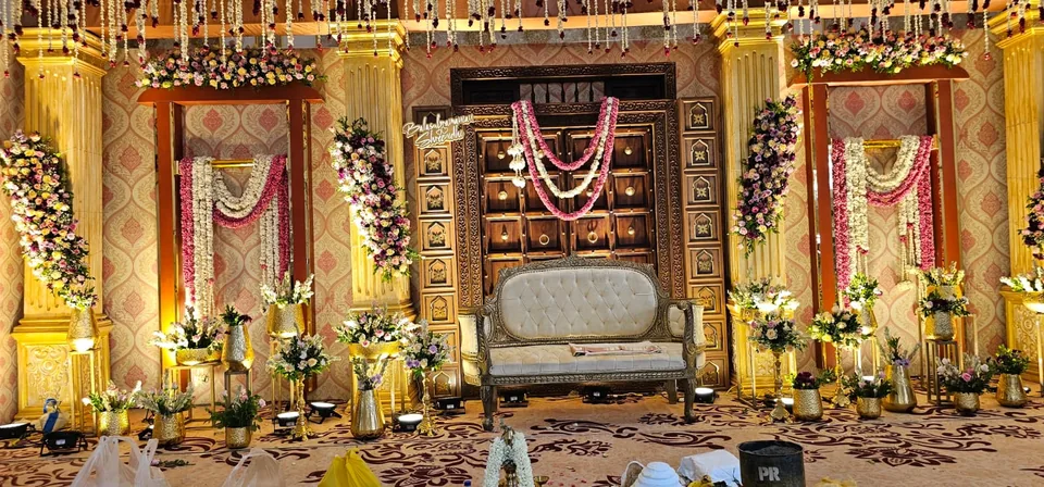 Royal gold mandap with ornate seat and dense floral garlands