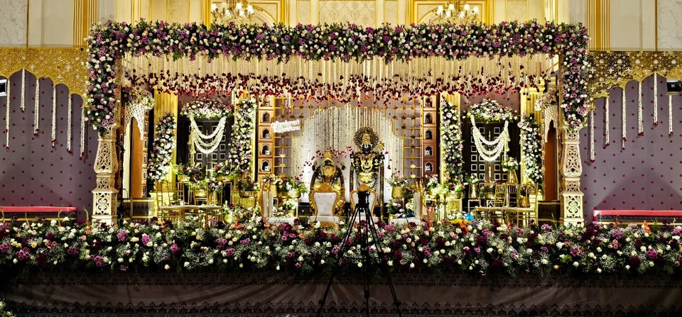 Traditional gold and maroon mandap with garlands and carved pillars